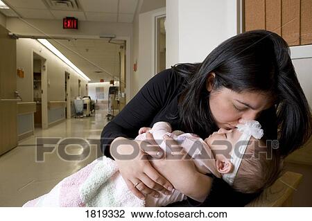 Stock Image - Woman kissing baby girl. Fotosearch