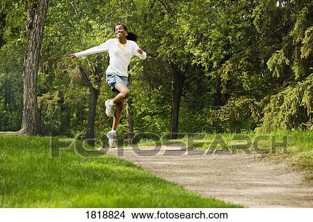 Woman skipping down a pathway View Large Photo Image Picture - Woman skipping down a pathway. Fotosearch