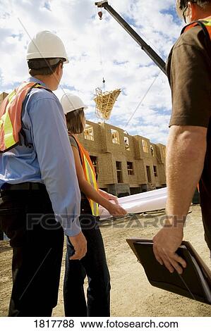 Stock Photo - Workers at a construction site. Fotosearch