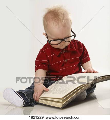 Stock Photo - A baby boy looking at a book. Fotosearch