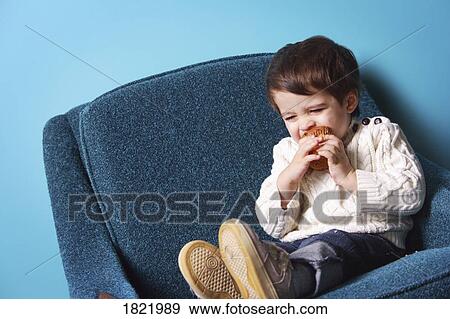 Stock Photo - A boy eating a muffin. Fotosearch