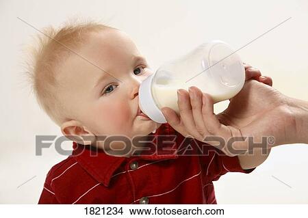 Baby boy drinking from a bottle View Large Photo Image Picture - Baby boy drinking from a bottle. Fotosearch