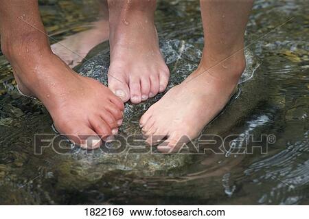Stock Photo - Children standing on rock in stream . Fotosearch