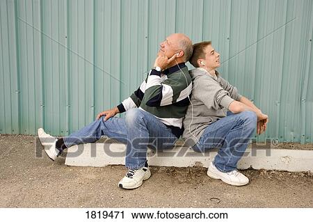 Stock Image - Grandfather and grandson listening to music. Fotosearch