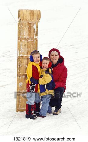 Stock Photo - Grandma and grandsons standing with toboggan. Fotosearch