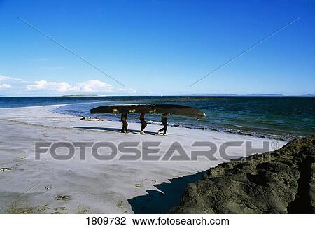 Stock Image - Islanders carrying a currach, Inishmore, The Aran Islands, Co Galway, Ireland. Fotosearch