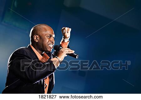 Stock Photo - Man speaking into microphone. Fotosearch