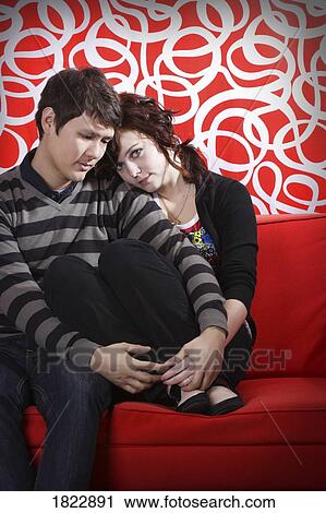 A couple sitting on a couch View Large Photo Image Stock Image - A couple sitting on a couch. Fotosearch