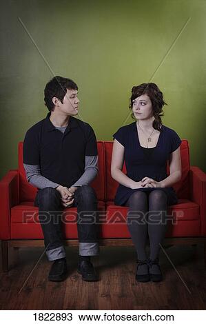 A couple sitting on a couch View Large Photo Image Stock Image - A couple sitting on a couch. Fotosearch