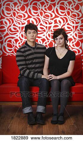 A couple sitting on a couch View Large Photo Image Stock Photo - A couple sitting on a couch. Fotosearch