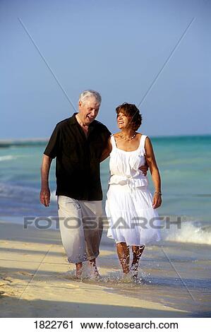 A senior couple walking along the beach View Large Photo Image Stock Image - A senior couple walking along the beach. Fotosearch