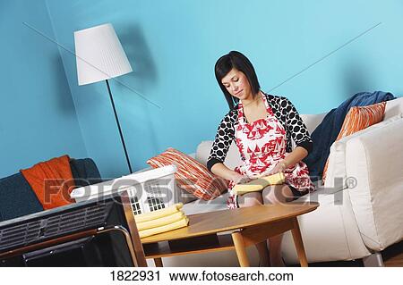 Stock Image - A woman folding laundry. Fotosearch