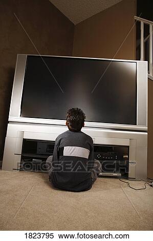 Boy sitting in front of a television View Large Photo Image Stock Photography - Boy sitting in front of a television. Fotosearch