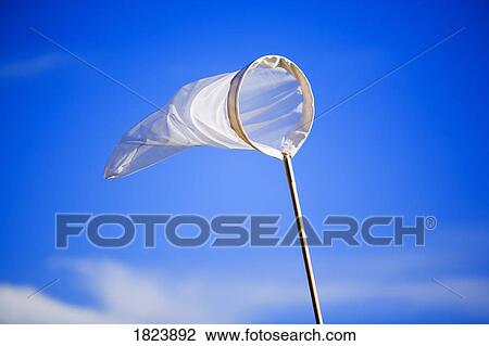 Stock Image - Butterfly net against blue sky . Fotosearch