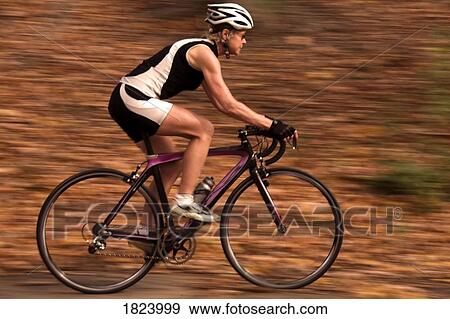 Stock Photo - Cyclist on recreational trail in the autumn . Fotosearch