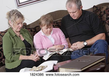 Stock Photograph - Family praying together. Fotosearch