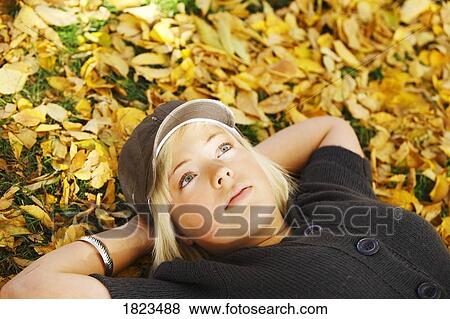 Stock Photo - Girl laying in the leaves. Fotosearch
