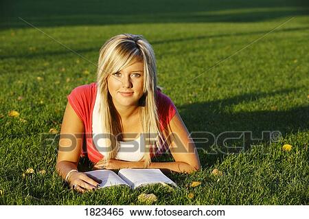 Girl reading in the grass View Large Photo Image Stock Photography - Girl reading in the grass. Fotosearch