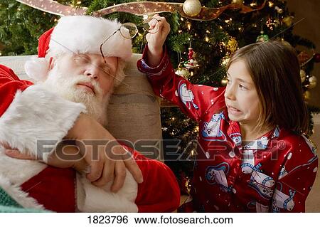 Girl taking glasses off sleeping Santa View Large Photo Image Stock Photograph - Girl taking glasses off sleeping Santa. Fotosearch
