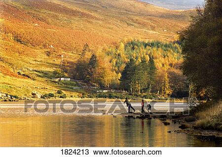 Stock Image - Kids playing by the water in Loch Lobhair, Scotland. Fotosearch