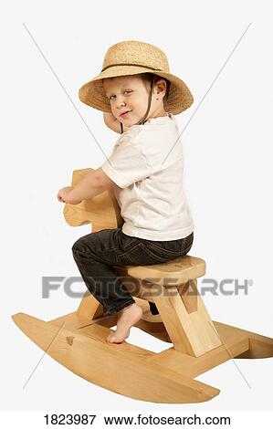 Stock Photo - Little boy on a rocking horse . Fotosearch
