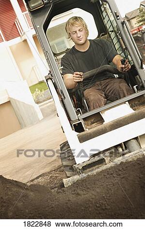 Stock Photo - Man operating a skid loader. Fotosearch