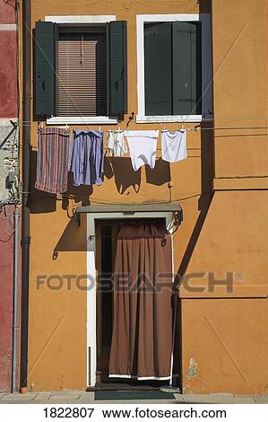 Orange house with hanging laundry, Burano, Italy View Large Photo Image Stock Photo - Orange house with hanging laundry, Burano, Italy . Fotosearch