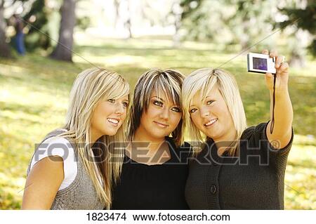Three girls taking a photo of themselves View Large Photo Image Picture - Three girls taking a photo of themselves. Fotosearch