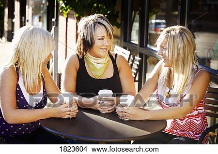 Picture - Three teens having drinks together. Fotosearch