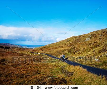 Stock Image - Tractor on country Road near Glencolumbkille, Co Donegal, Ireland. Fotosearch