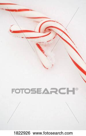 Stock Photograph - Two candy canes in the snow. Fotosearch