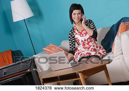Stock Photo - Woman at home talking on the phone and on the computer. Fotosearch