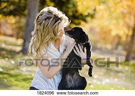 Woman holding dog View Large Photo Image Stock Photograph - Woman holding dog. Fotosearch