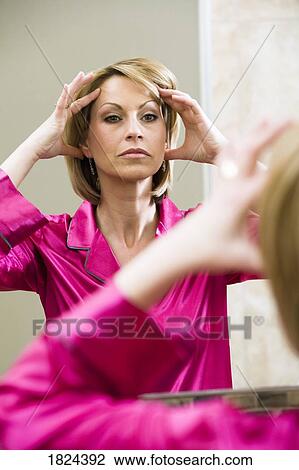 Woman looking at self in mirror View Large Photo Image Stock Image - Woman looking at self in mirror. Fotosearch