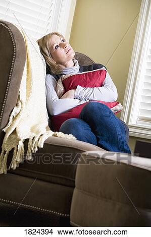 Woman sitting on couch View Large Photo Image Picture - Woman sitting on couch. Fotosearch