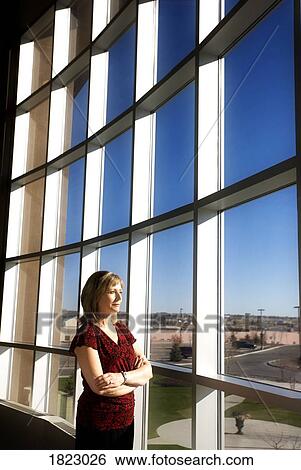 Stock Photograph - Woman watching out a window. Fotosearch