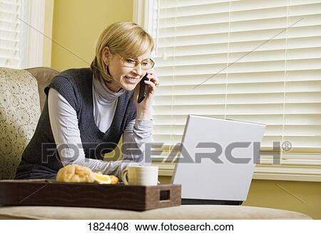 Stock Photo - Woman working on laptop computer from home. Fotosearch