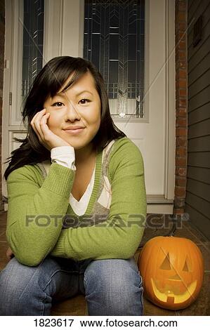 Stock Photo - Young girl with carved pumpkin. Fotosearch