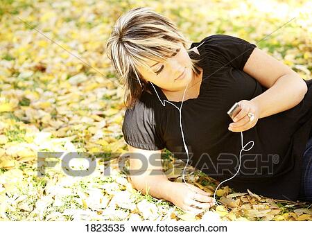 Young woman listening to music View Large Photo Image Stock Photography - Young woman listening to music. Fotosearch
