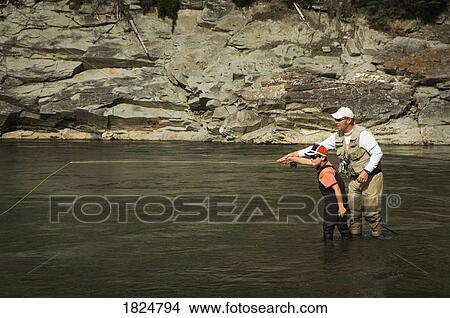 Picture - Father and son in a mountain fly fishing river, Nordegg, Alberta, Canada . Fotosearch