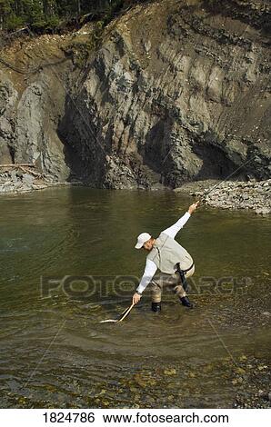 Stock Photograph - Man fly fishing in a mountain river, Nordegg, Alberta, Canada. Fotosearch