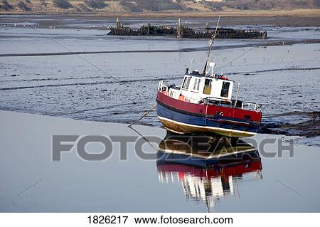 Stock Photo - A boat moored by shore, Amble, Northumberland, England. Fotosearch