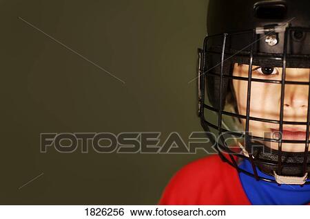 Stock Photograph - A boy wearing a hockey helmet. Fotosearch