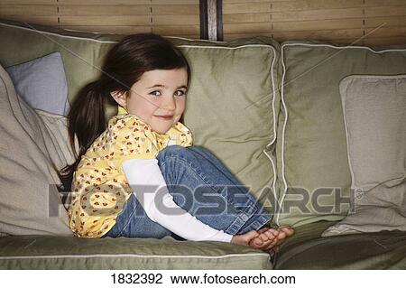 A little girl sitting on a couch View Large Photo Image Stock Image - A little girl sitting on a couch. Fotosearch