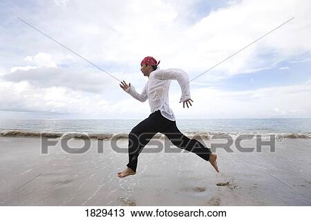 A man running along the beach View Large Photo Image Stock Image - A man running along the beach. Fotosearch