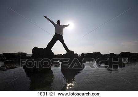 Stock Image - A man stretching on a beach in Koh Lanta, Thailand. Fotosearch