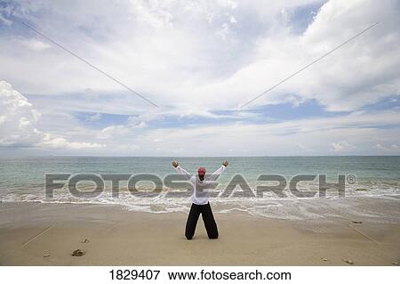 A man with arms outstretched on a beach in Koh Lanta, Thailand View Large Photo Image Stock Photo - A man with arms outstretched on a beach in Koh Lanta, Thailand. Fotosearch