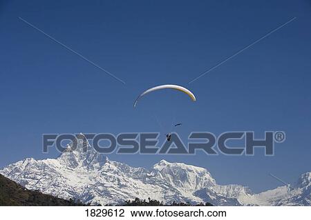 Stock Image - A paraglider in the Annapurna Region near Pokhara, Nepal. Fotosearch