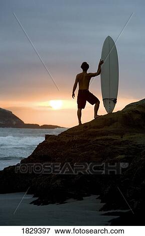 A surfer on Muriwai Beach, New Zealand View Large Photo Image Stock Photo - A surfer on Muriwai Beach, New Zealand. Fotosearch