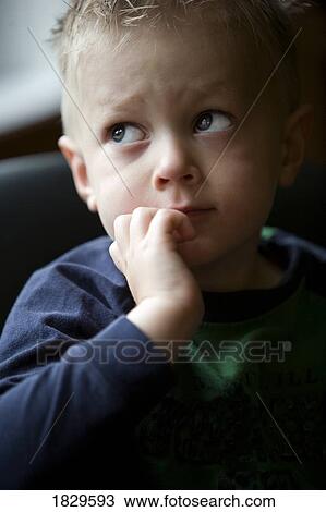 Stock Image - A young boy looking up. Fotosearch